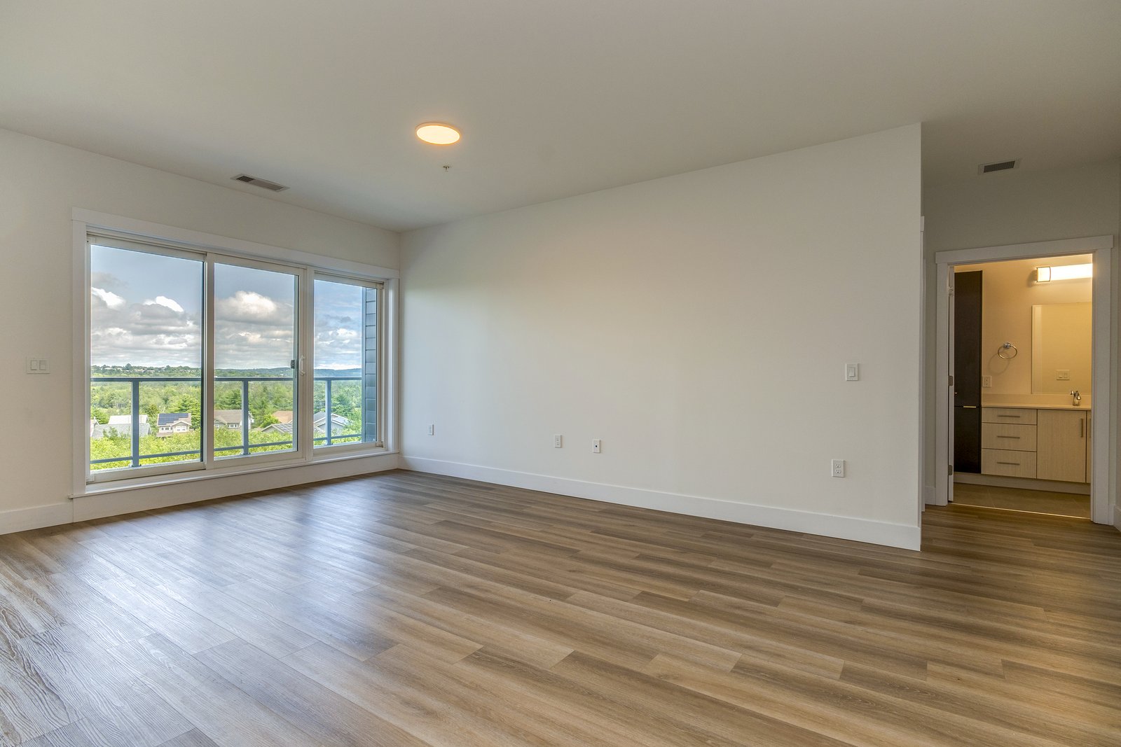 Primary bedroom with balcony access and an ensuite doorway