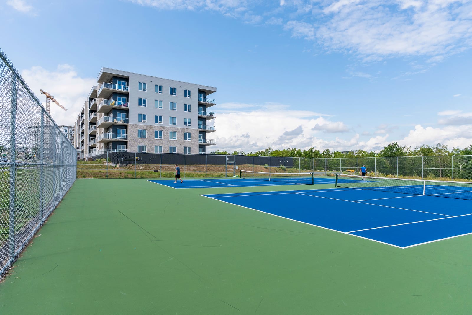 Ground-level view of the tennis and pickleball courts with the building behind