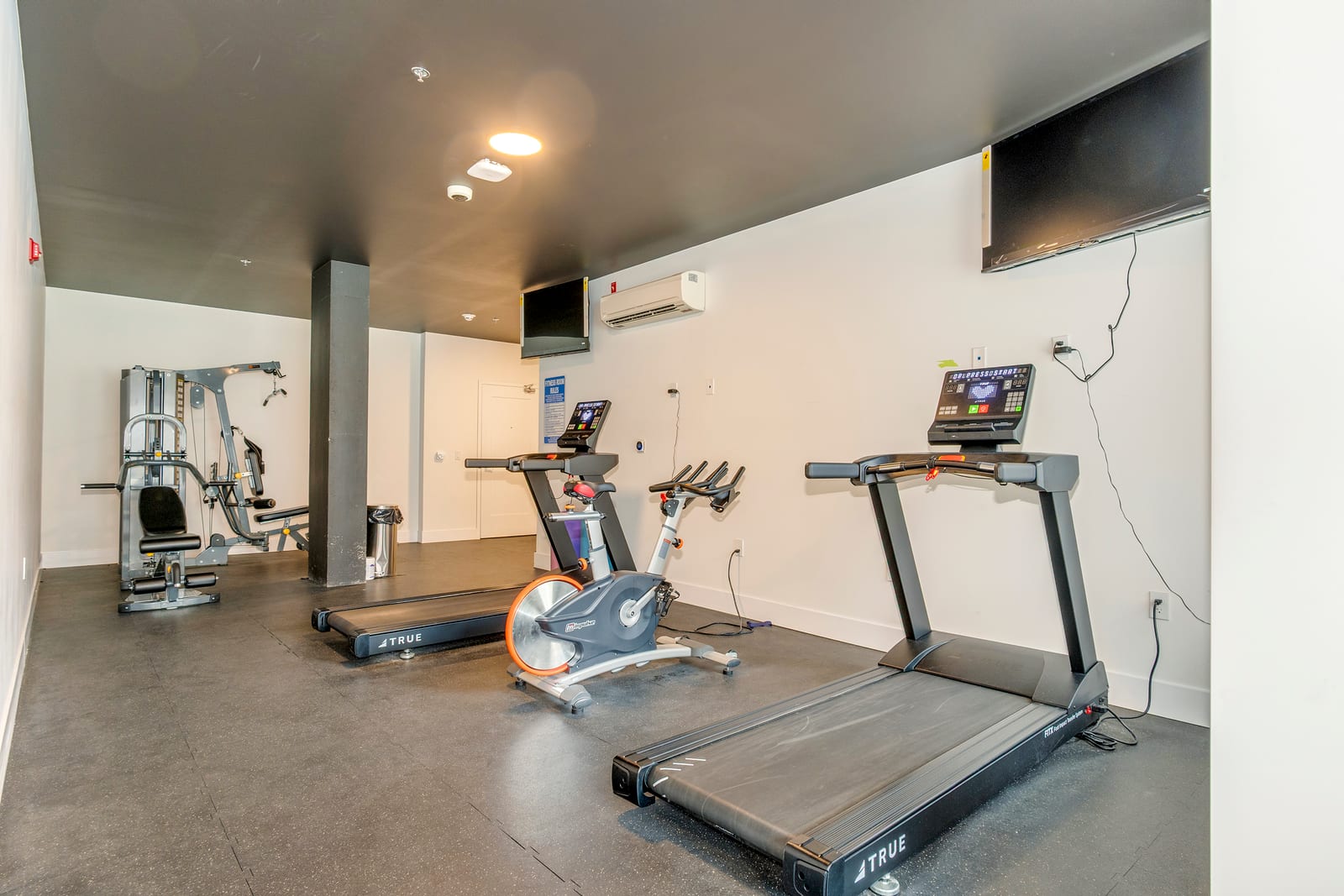On-site fitness room with treadmills, a stationary bike, and a weight machine