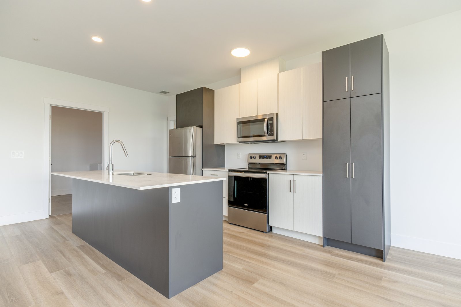 Kitchen with an island, sink, fridge, and stainless appliances