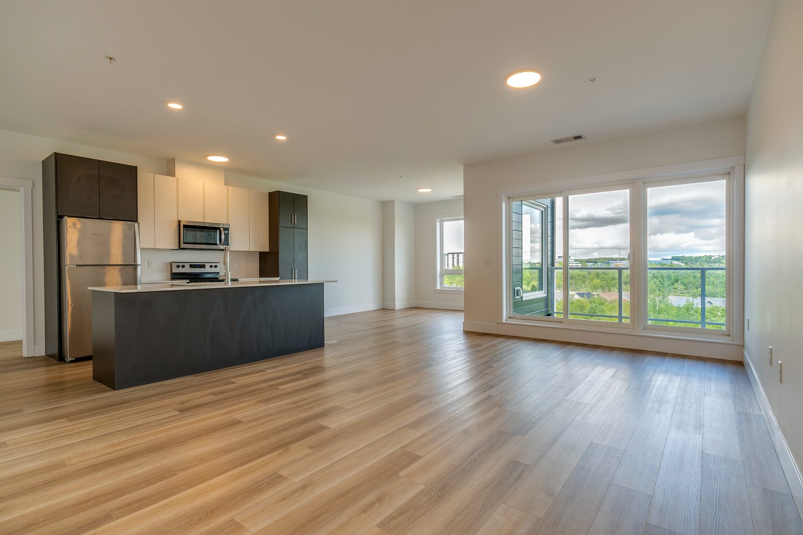 Open kitchen and living area with balcony doors and natural light
