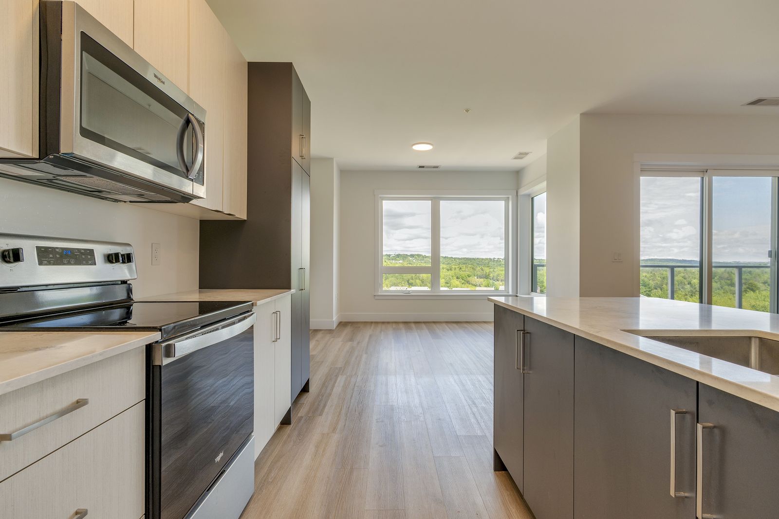 Kitchen and living area with a large window overlooking the treeline